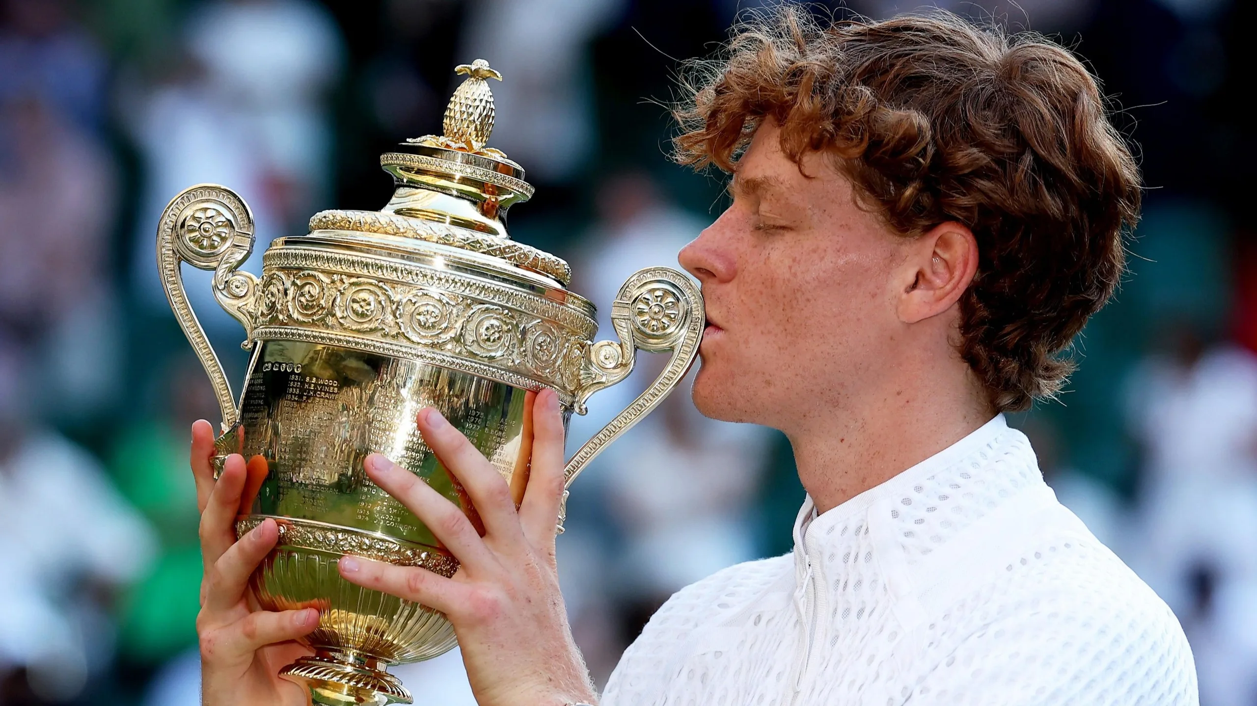 Jannik Sinner kisses the Wimbledon trophy after beating Alexander Zverev in the men's final