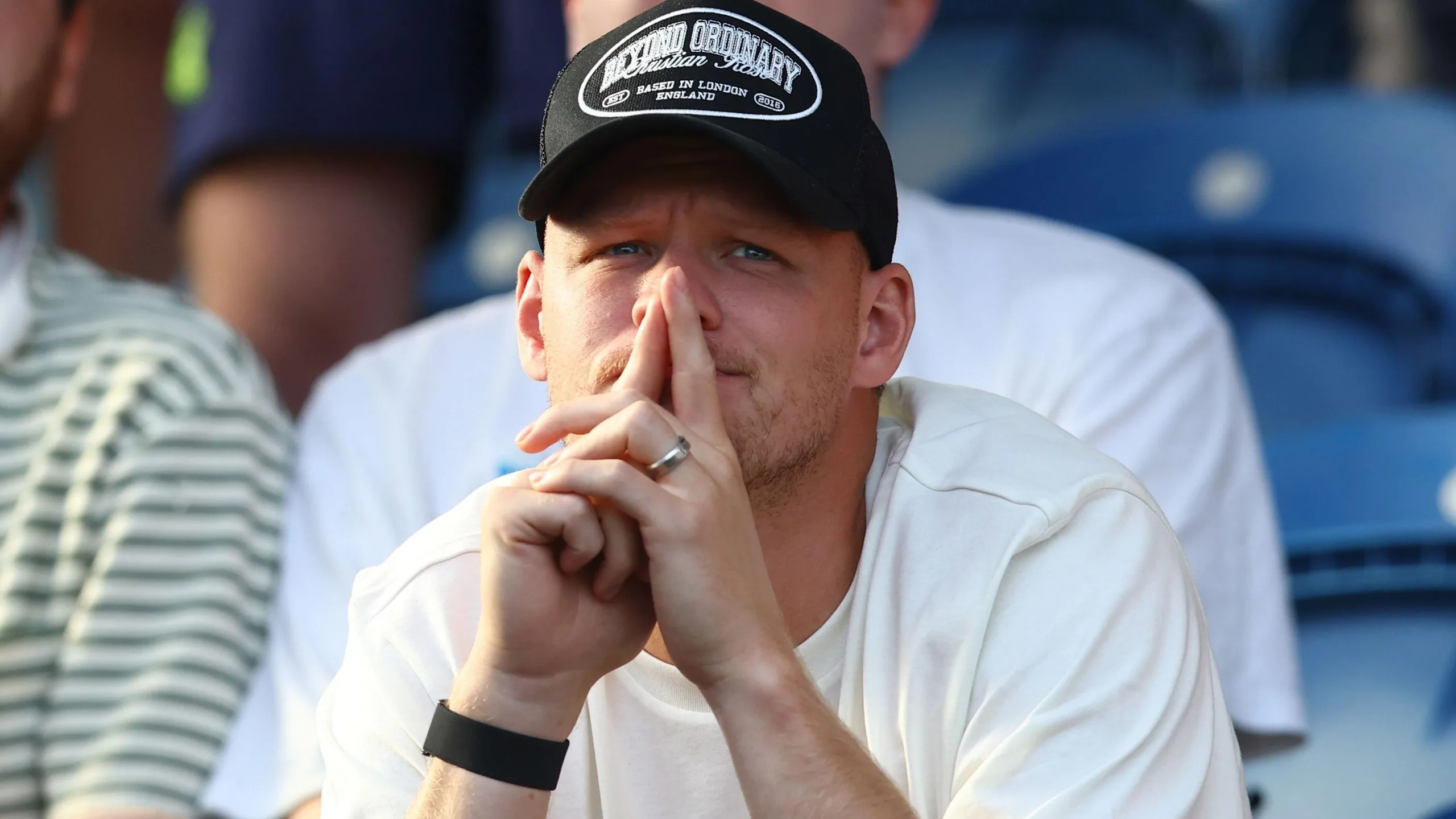Aaron Ramsdale, wearing a black baseball cap and white t-shirt, watches Southampton's EFL Cup game at Colchester United from the stands 
