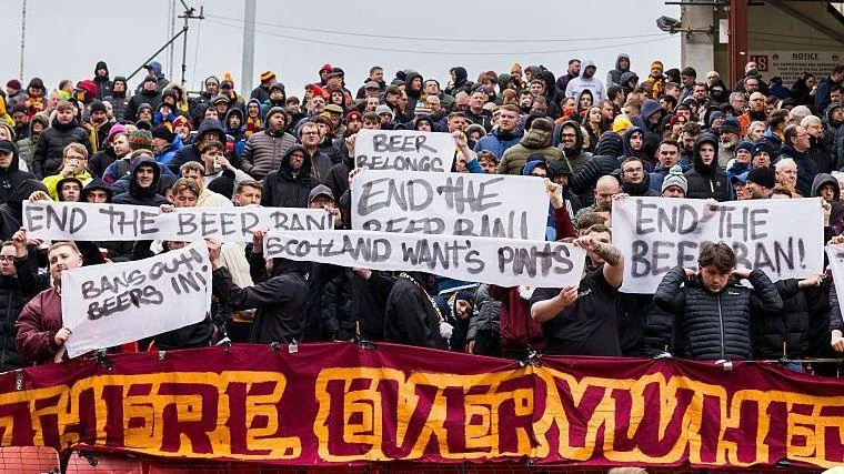 Motherwell fans hold signs protesting the alcohol ban at Scottish football grounds