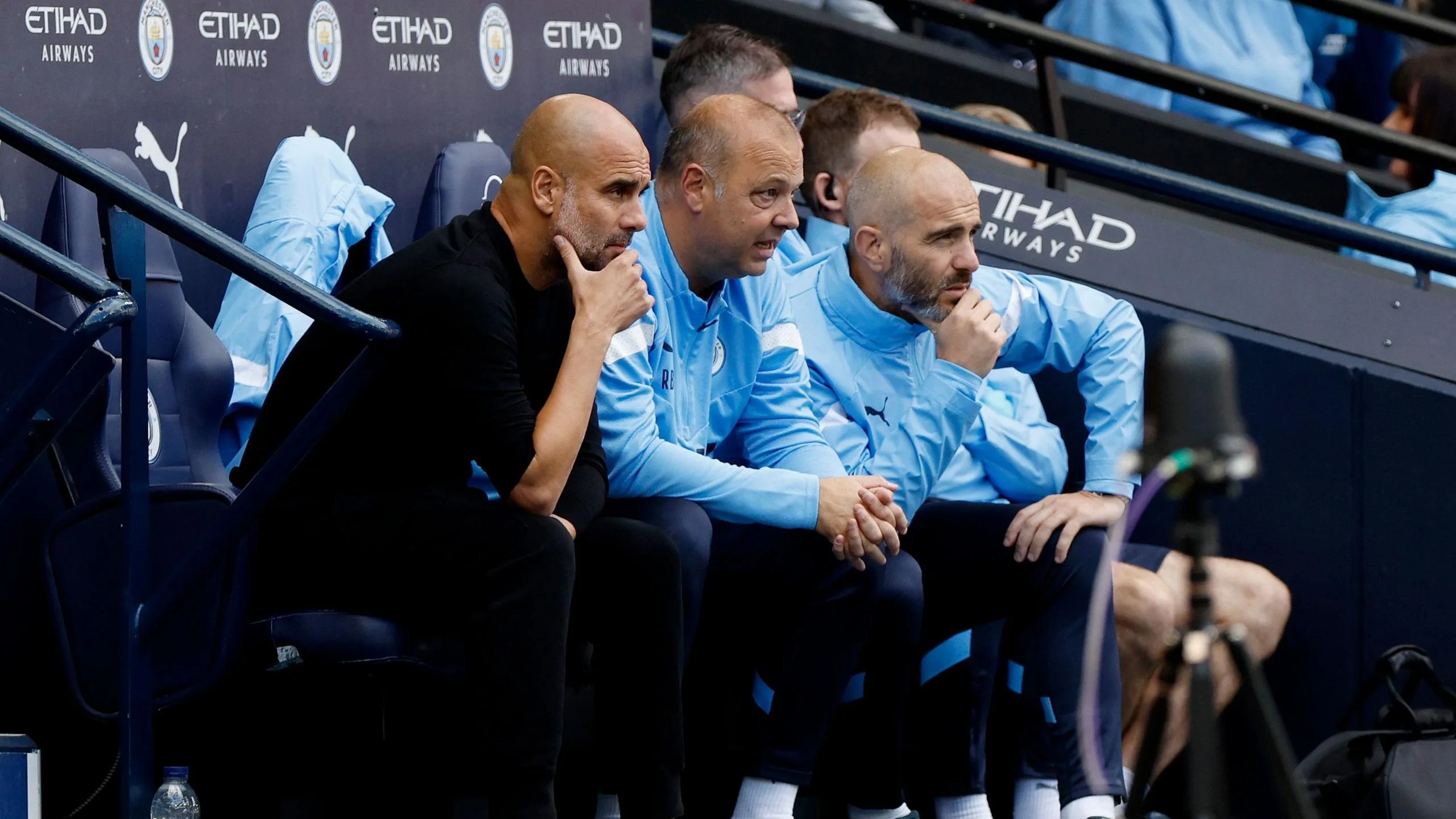 Pep Guardiola watches alongside assistants Rodolfo Borrell and Enzo Maresca during the Premier League match between Manchester City and Manchester United at Etihad Stadium on October 2 2022