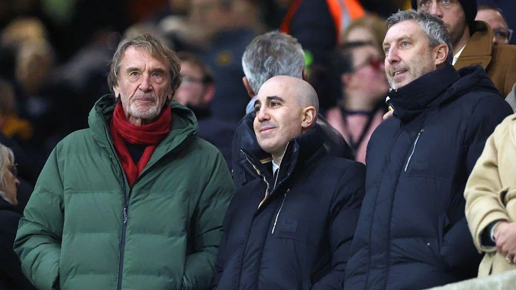 Manchester United minority owner Sir Jim Ratcliffe stands alongside chief executive Omar Berrada and director of football Jason Wilcox as all wear big coats