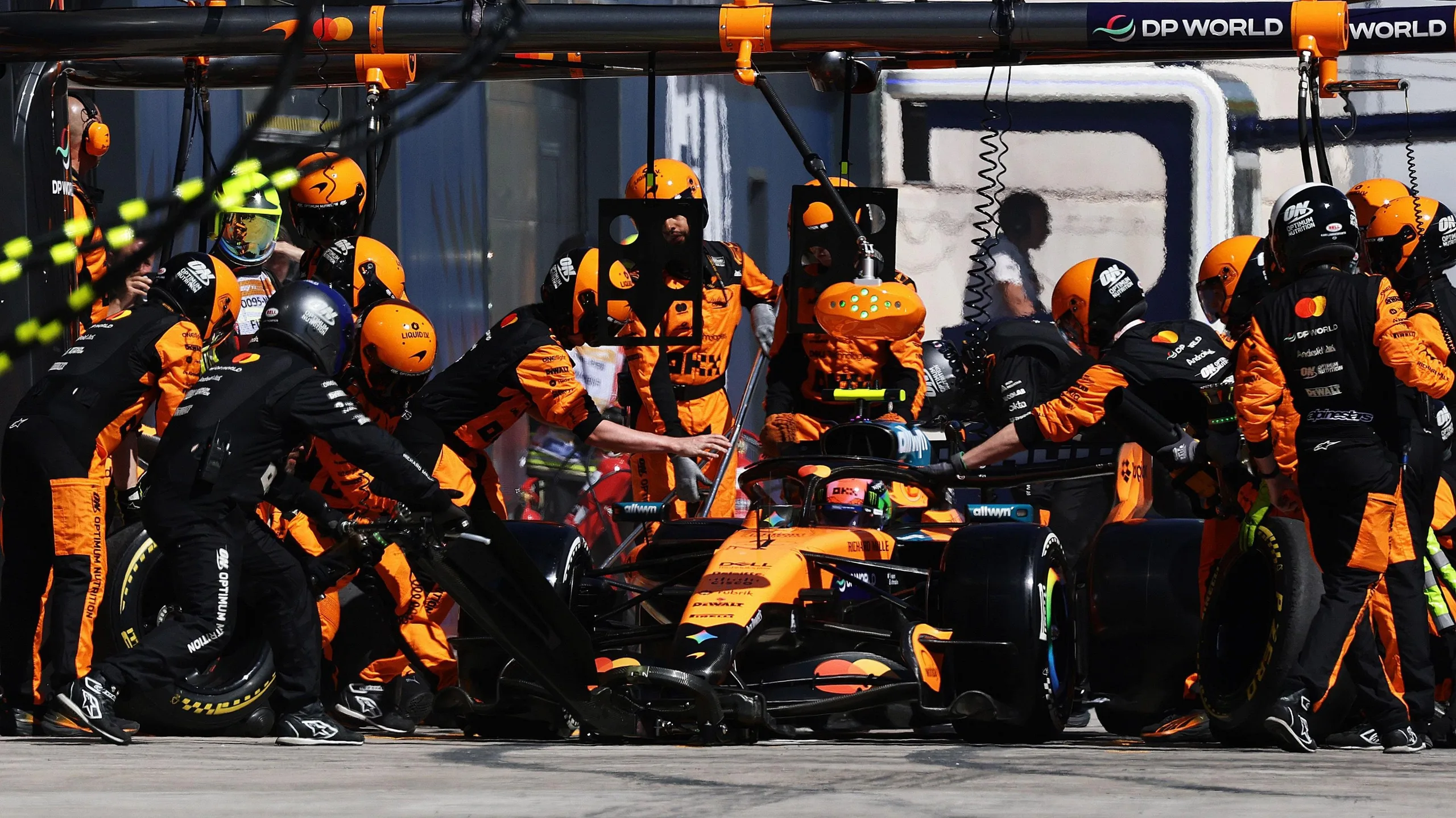 Lando Norris in the pit lane being serviced by McLaren mechanics during the Spanish Grand Prix