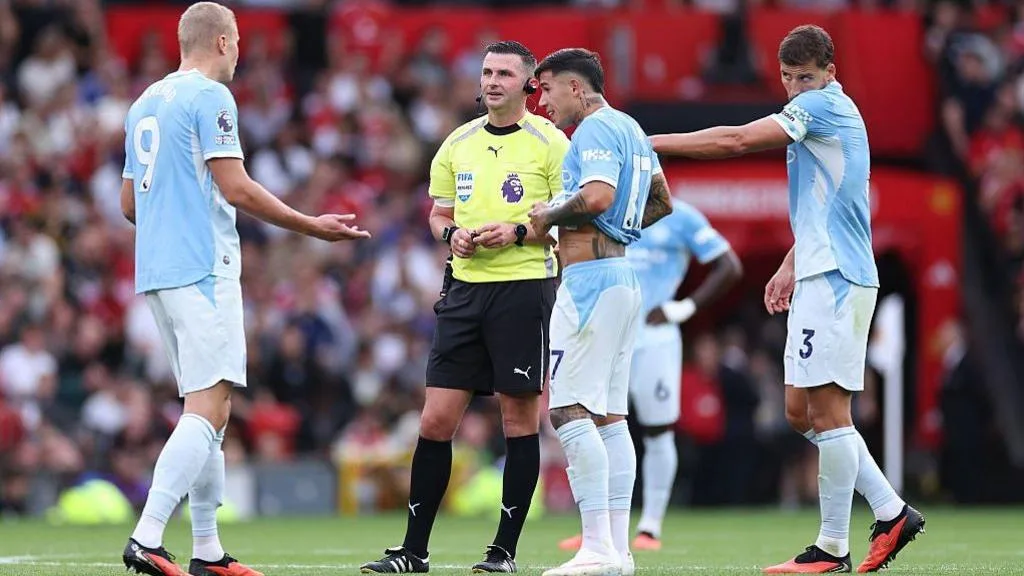 Erling Haaland of Manchester City speaks with referee Michael Oliver as a VAR check is performed after his goal is initially ruled offside