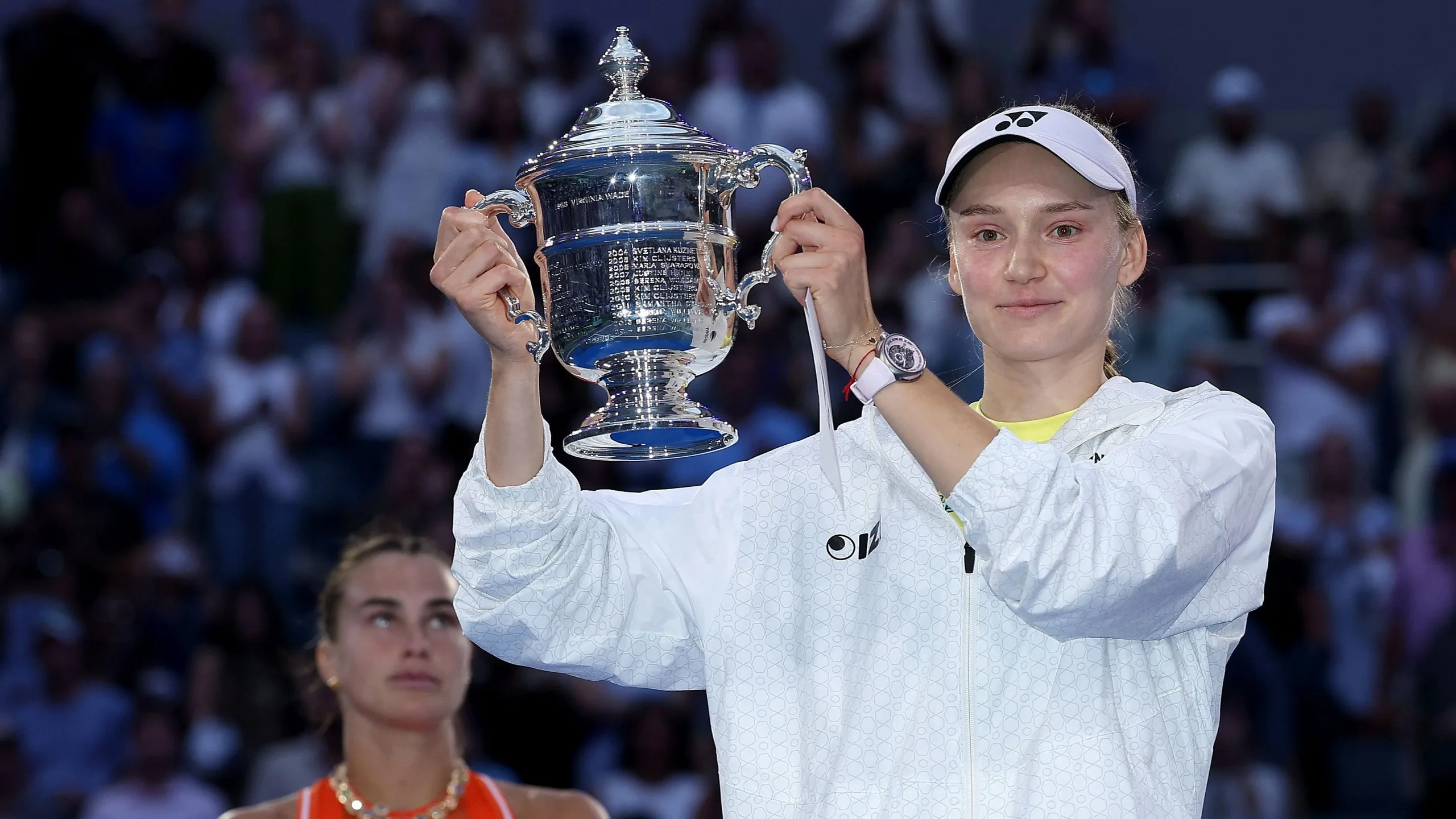 Elena Rybakina lifts the US Open trophy with Aryna Sabalenka looking on