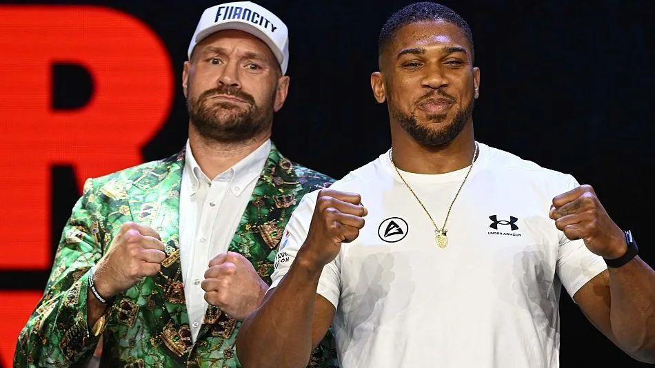 Anthony Joshua and Tyson Fury stand side-by-side and hold up their fists