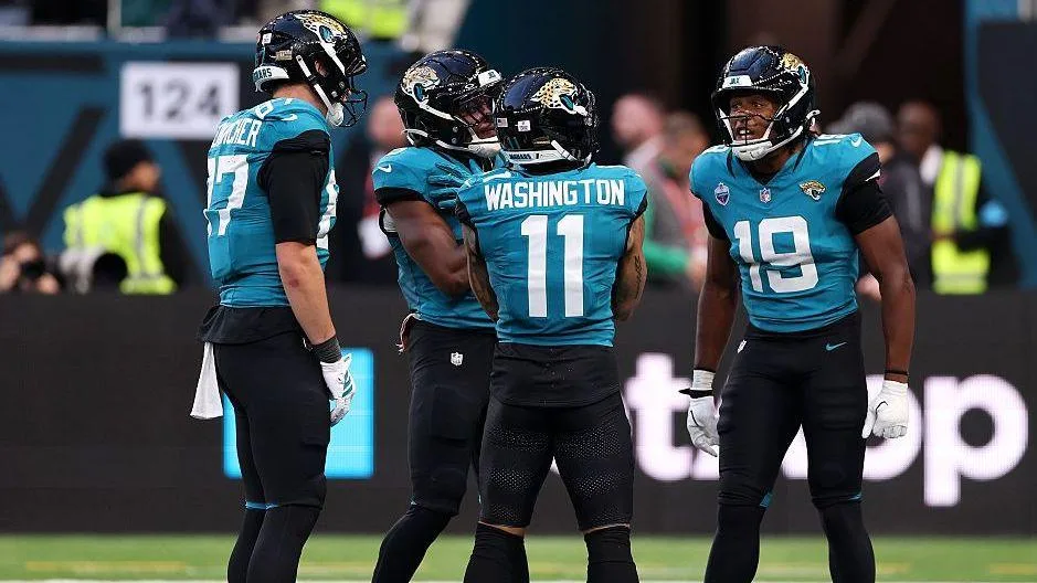 Parker Washinton rubs his arms as if he is cold, celebrating a touchdown