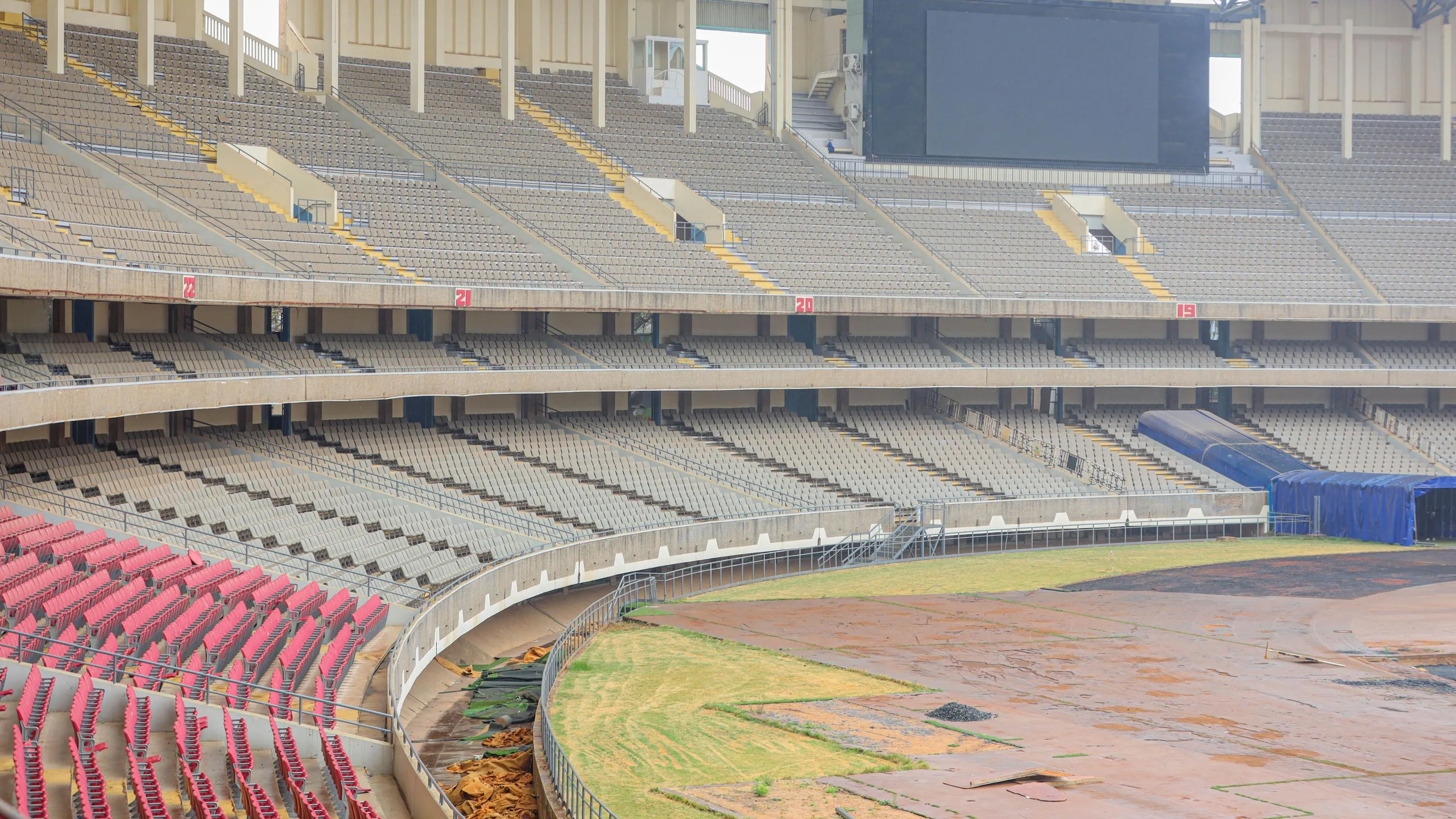 The Kasarani Stadium under renovation, showing a vast three-tier stand with only one section of seating and a bare field