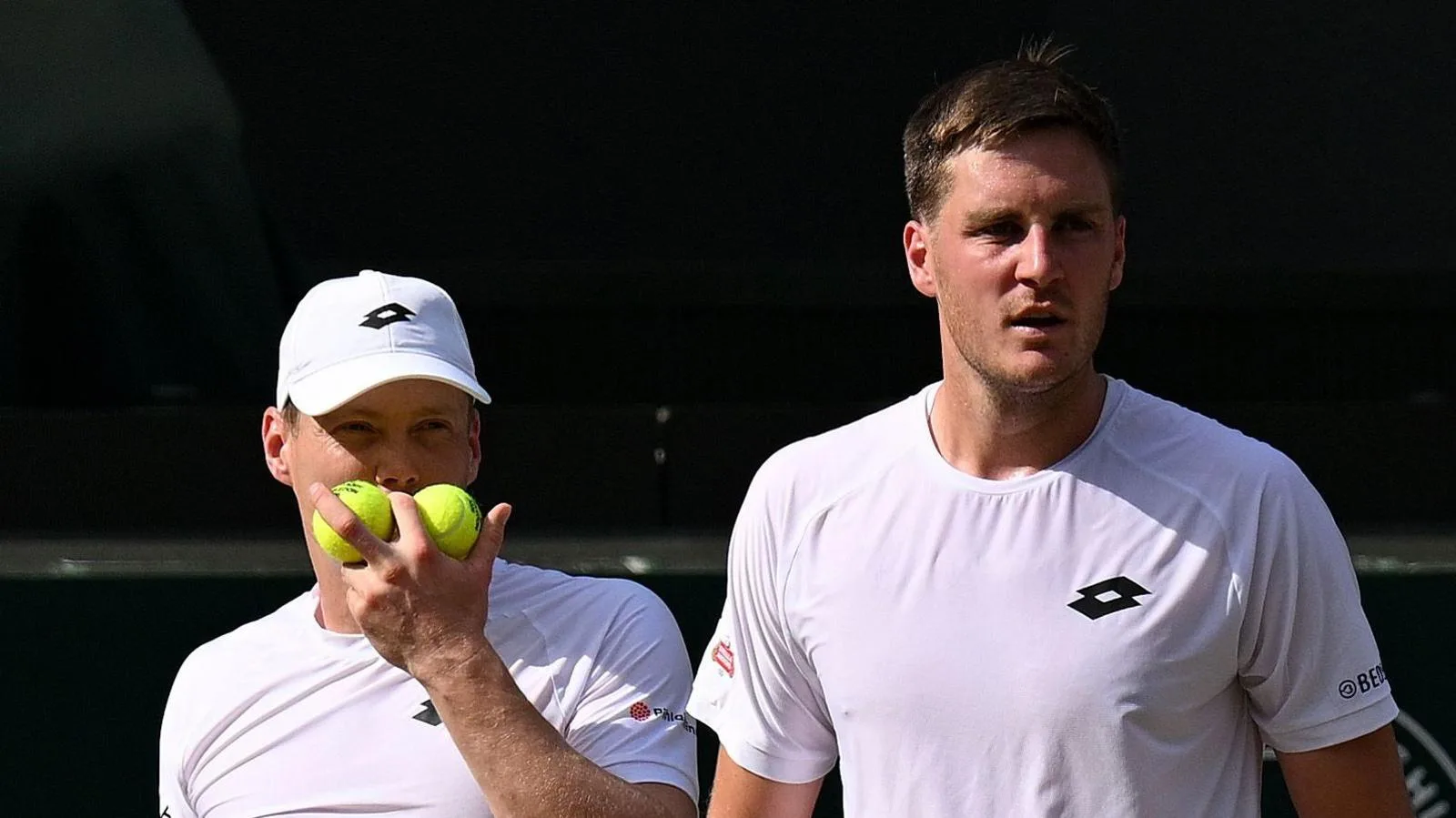 Harri Heliovaara and Henry Patten discuss tactics during the Wimbledon men's doubles final in July 2026