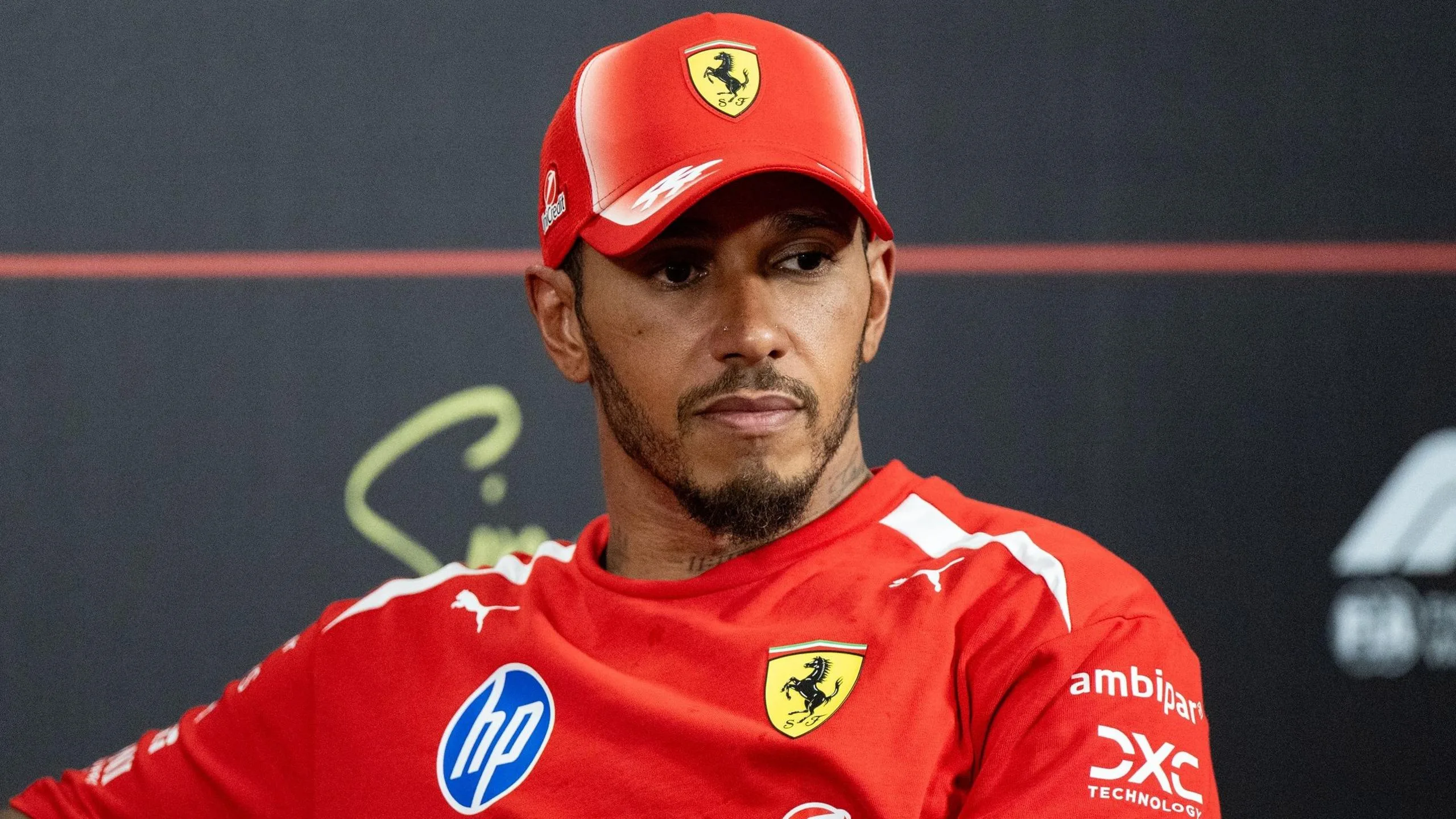 Lewis Hamilton with a pensive expression during a media commitment for Ferrari