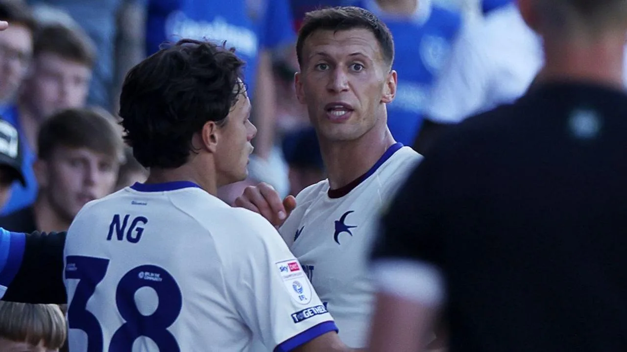 Krystian Bielik and Perry Ng, both in white and blue Cardiff City shirts, react at Portsmouth