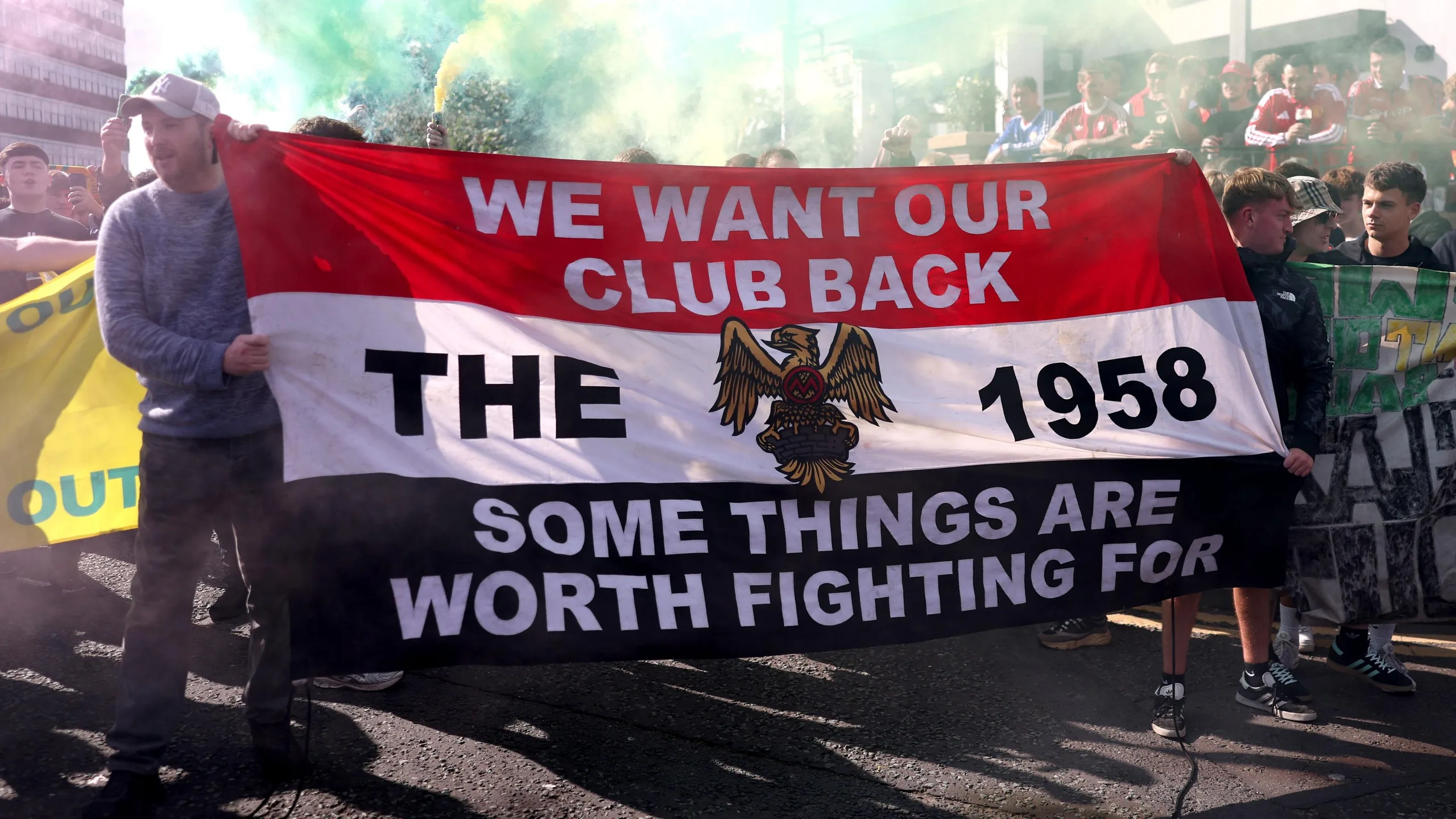 Manchester United fans display a banner in their protest outside Old Trafford which says "We want our club back. Some things are worth fighting for"