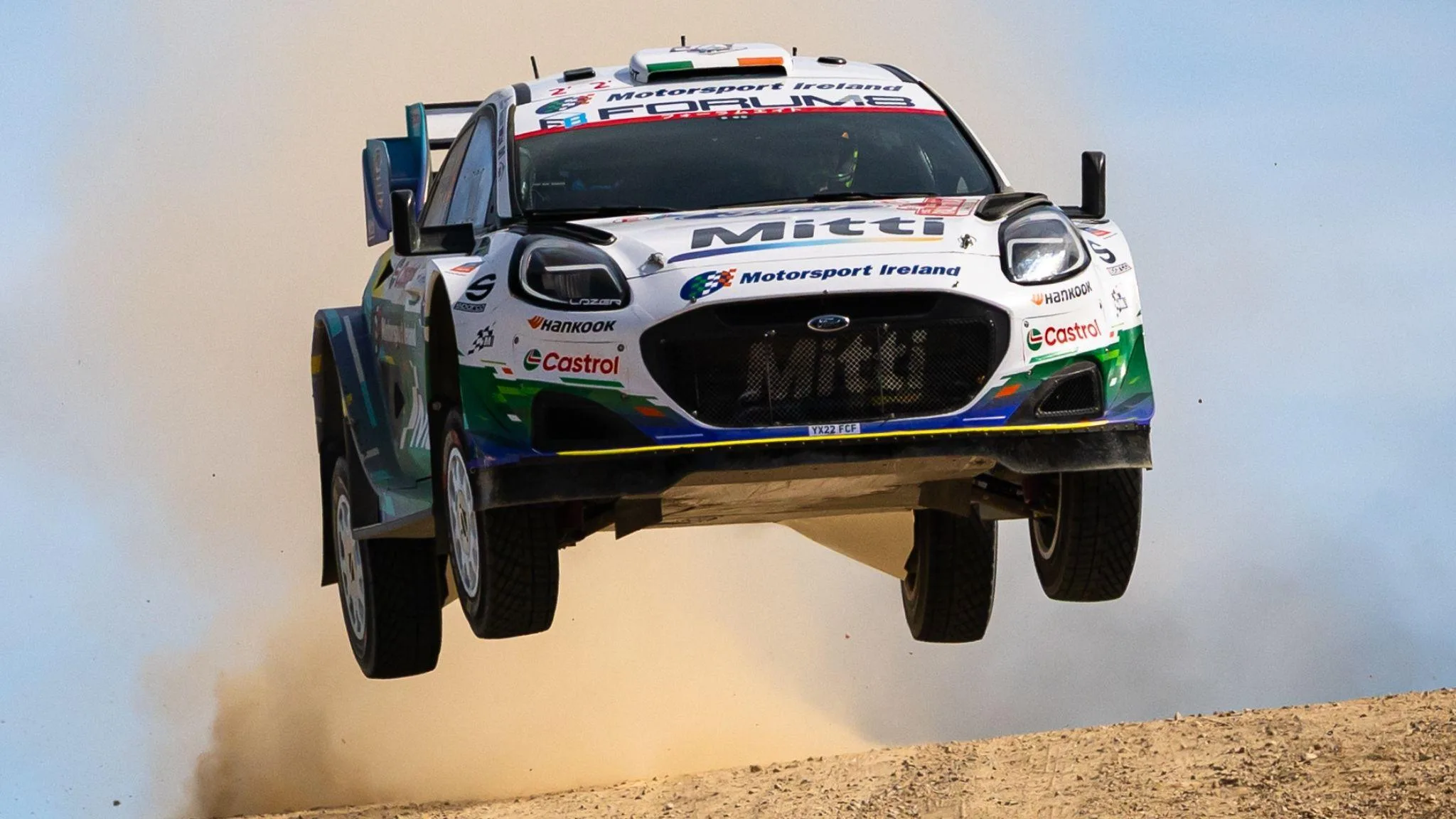 Jon Armstrong's Ford Puma takes to the air on a dusty gravel road