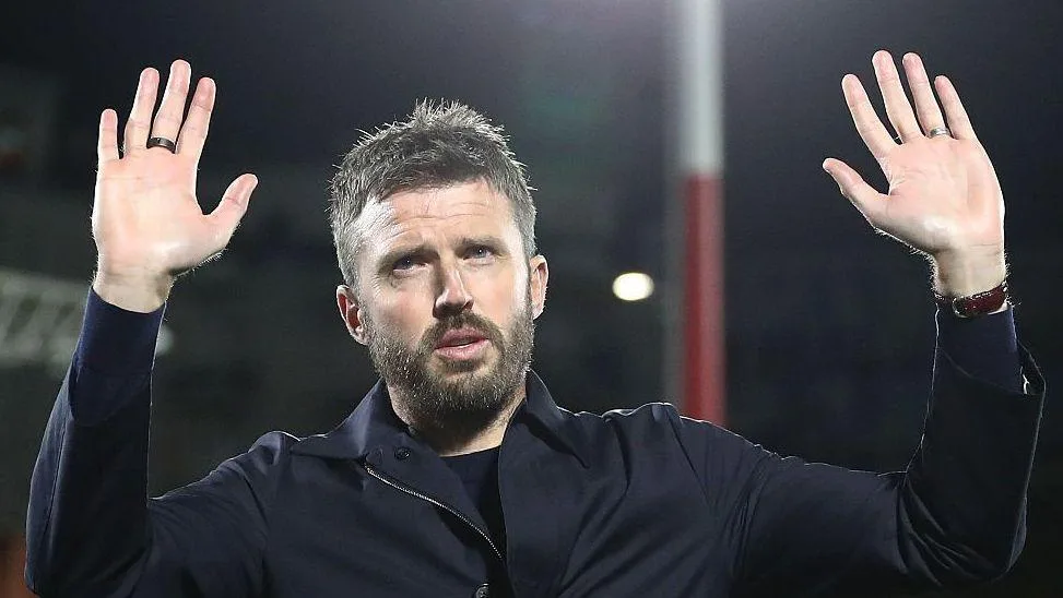 Manchester United head coach Michael Carrick holds his hands up to apologise to the away fans in Como