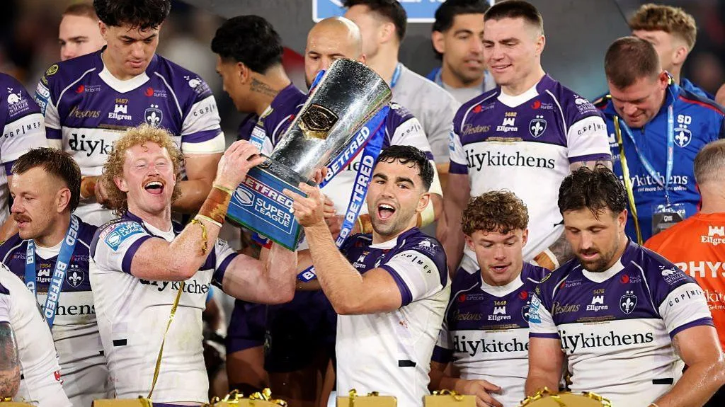 Lachlan Walmsley and Jack Sinfield holding aloft the Super League trophy  