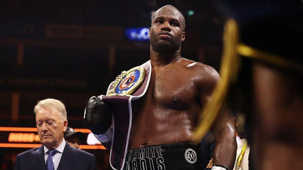 Daniel Dubois has the WBO heavyweight title on his shoulder as Frank Warren stands in the background