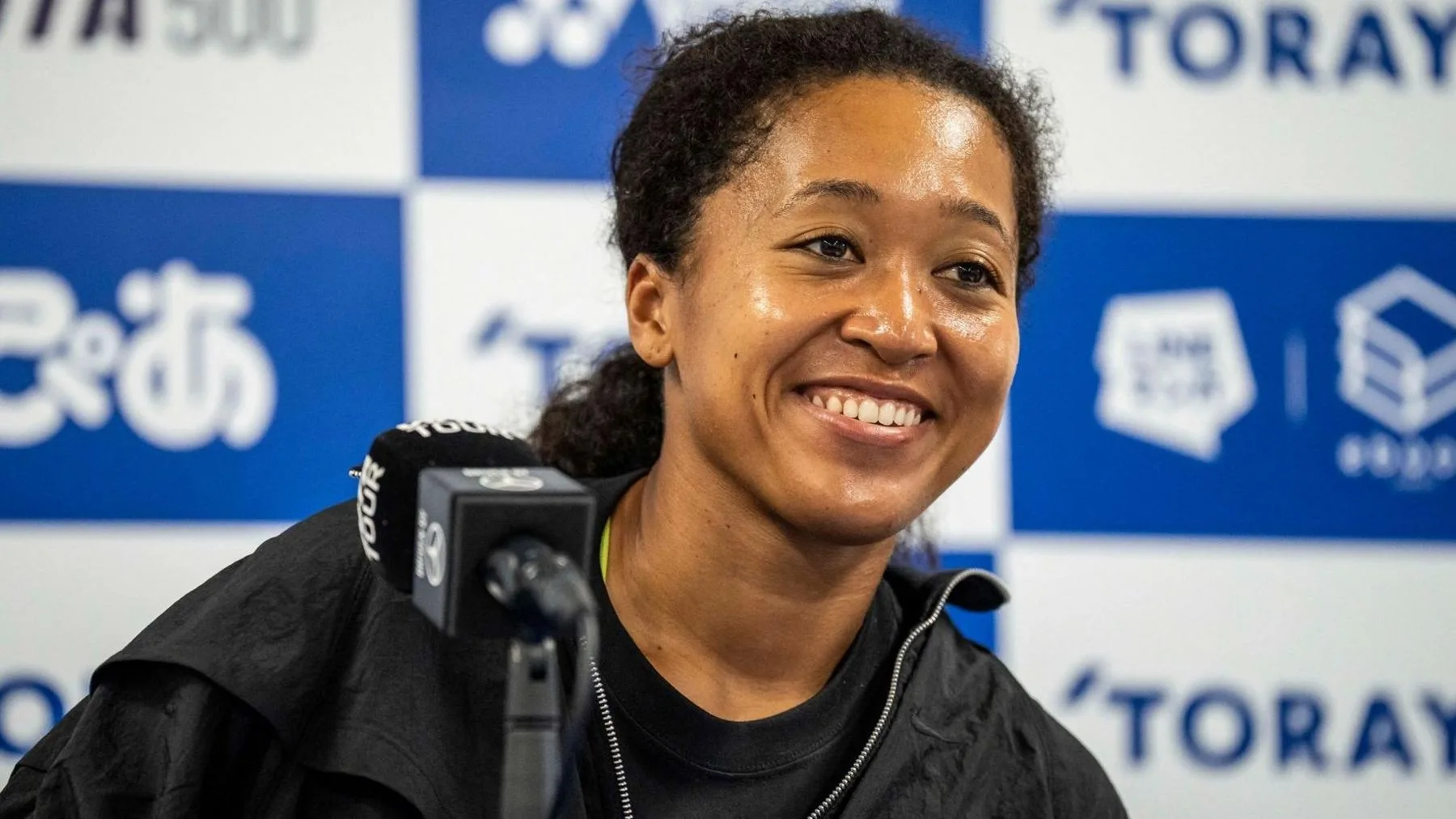 A head and shoulders photograph of a smiling Naomi Osaka