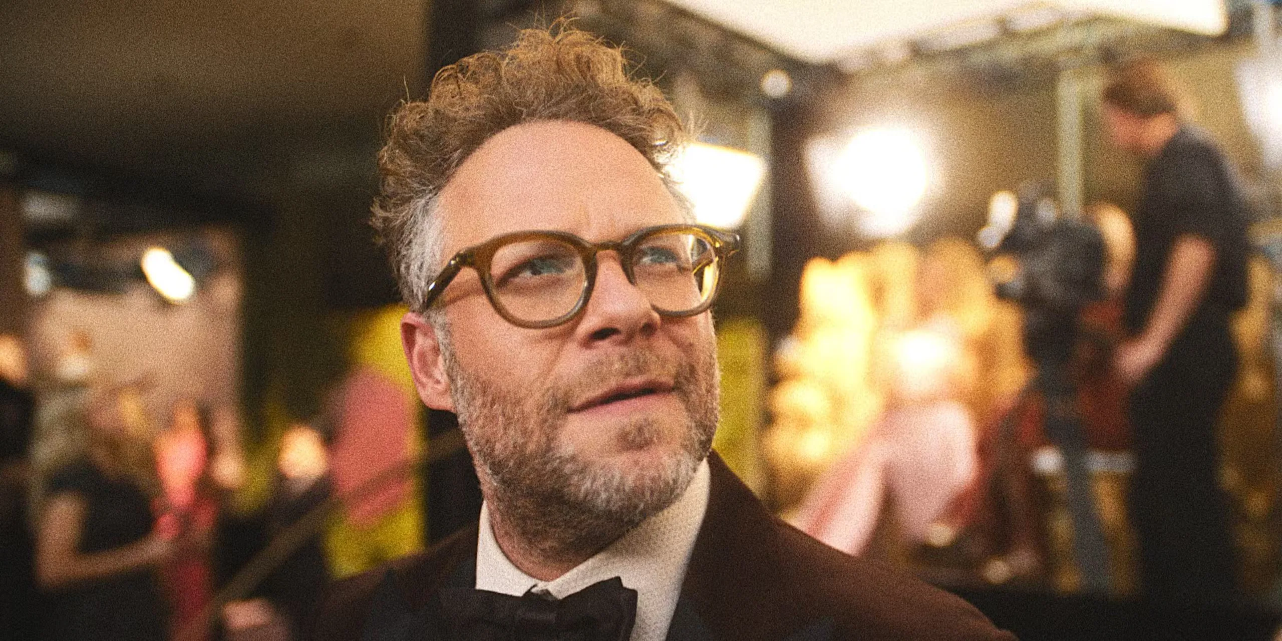 Seth Rogen looking up with a movie set behind him in The Studio.