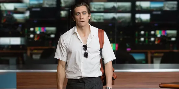 Jake Gyllenhaal stares blankly ahead in front of TV screens in Nightcrawler (2014)