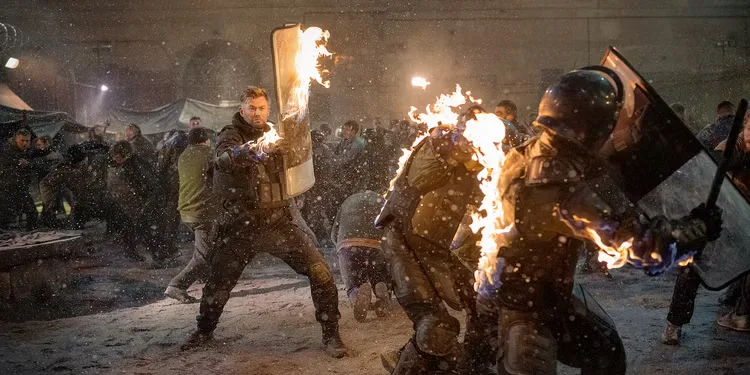 Chris Hemsworth as Tyler Rake fighting a crowd in Netflix's Extraction 2. 