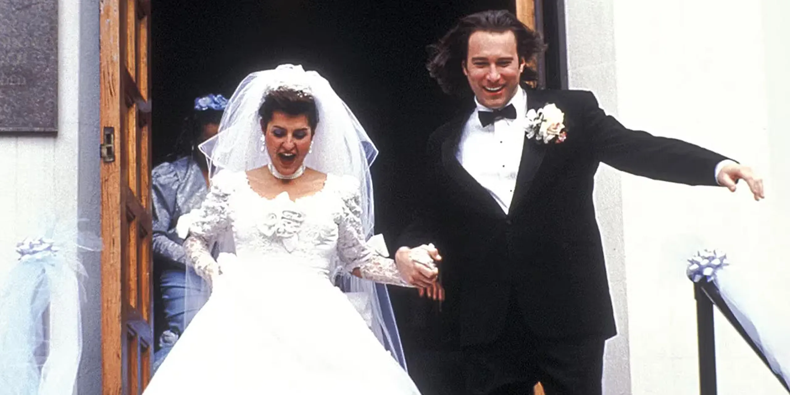 Nia Vardalos and John Corbett heading down the stairs after their wedding in My Big Fat Greek Wedding