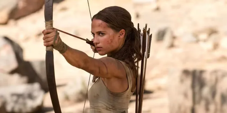 Alicia Vikander as Lara Croft aiming a bow and arrow in 'Tomb Raider'