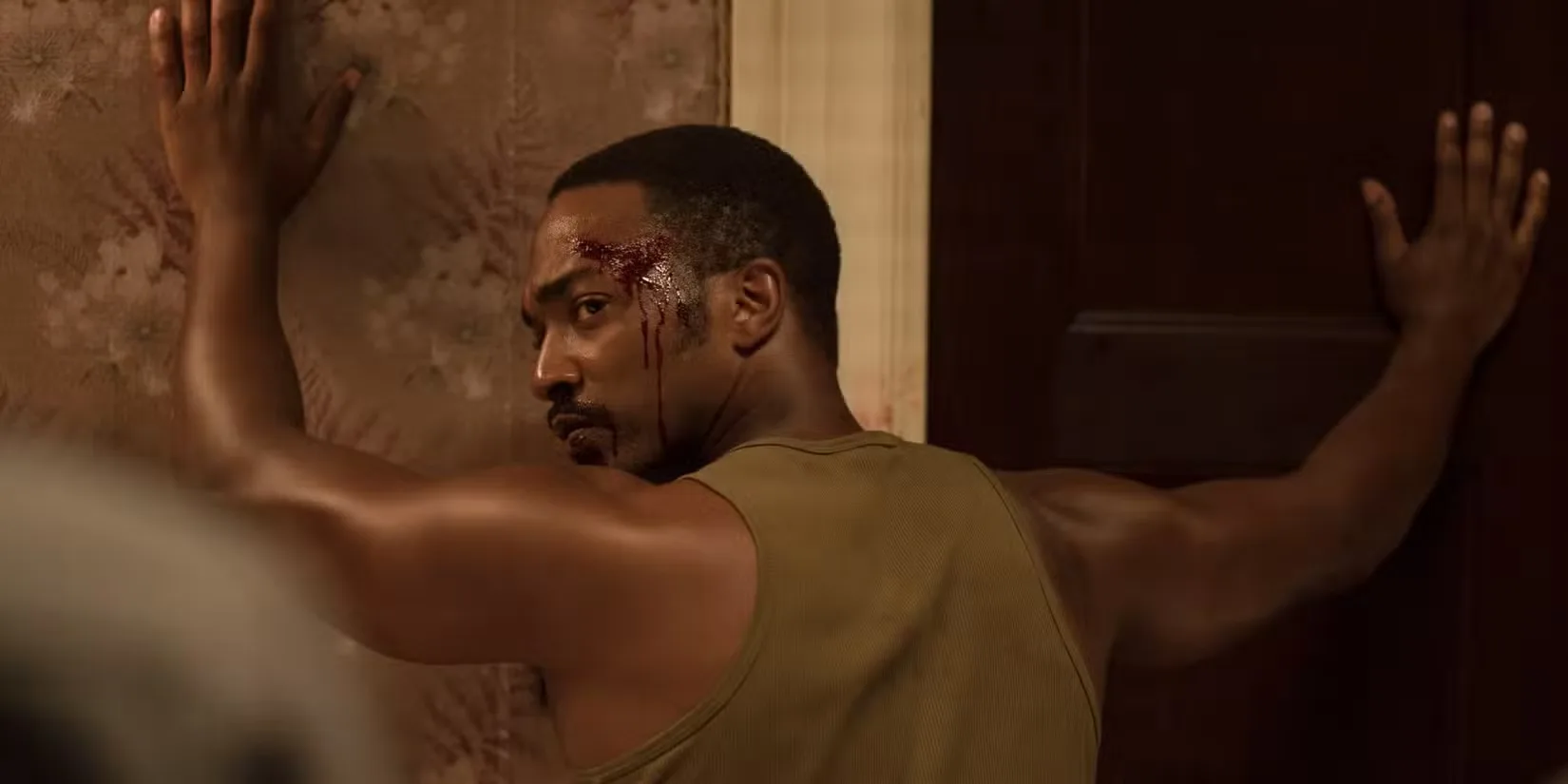 Anthony Mackie as Karl Greene with his hands against a wall turning around in Detroit