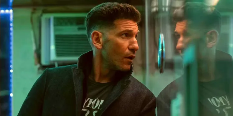 Jon Bernthal as Braxton leaning against a window in The Accountant 2.