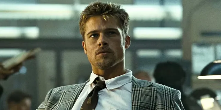 Brad Pitt looking intently while sitting at his desk in Se7en.