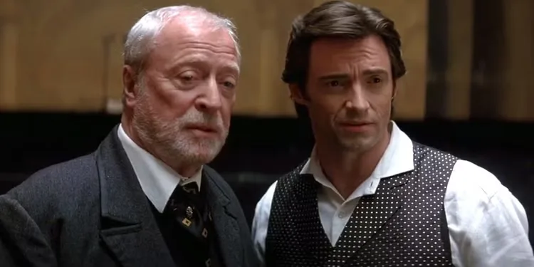 Michael Caine as John Cutter and Hugh Jackman as Robert Angier look in the same direction in The Prestige.