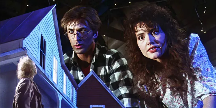 Adam and Barbara Maitland, played by actors Alec Baldwin and Geena Davis, look down on a model town in Beetlejuice.