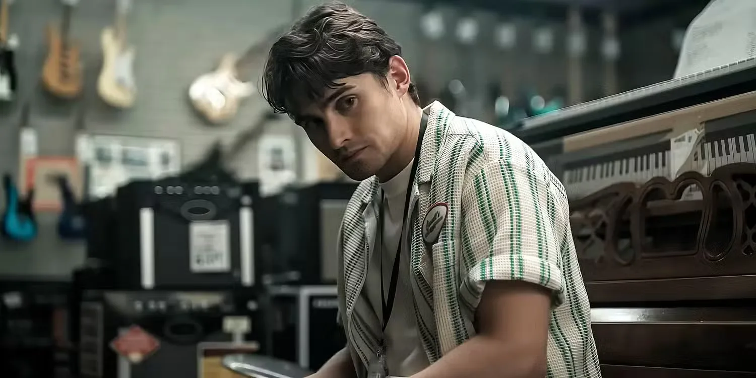 Michael Johnston sat on a piano stool wearing a lanyard in 'Obsession'
