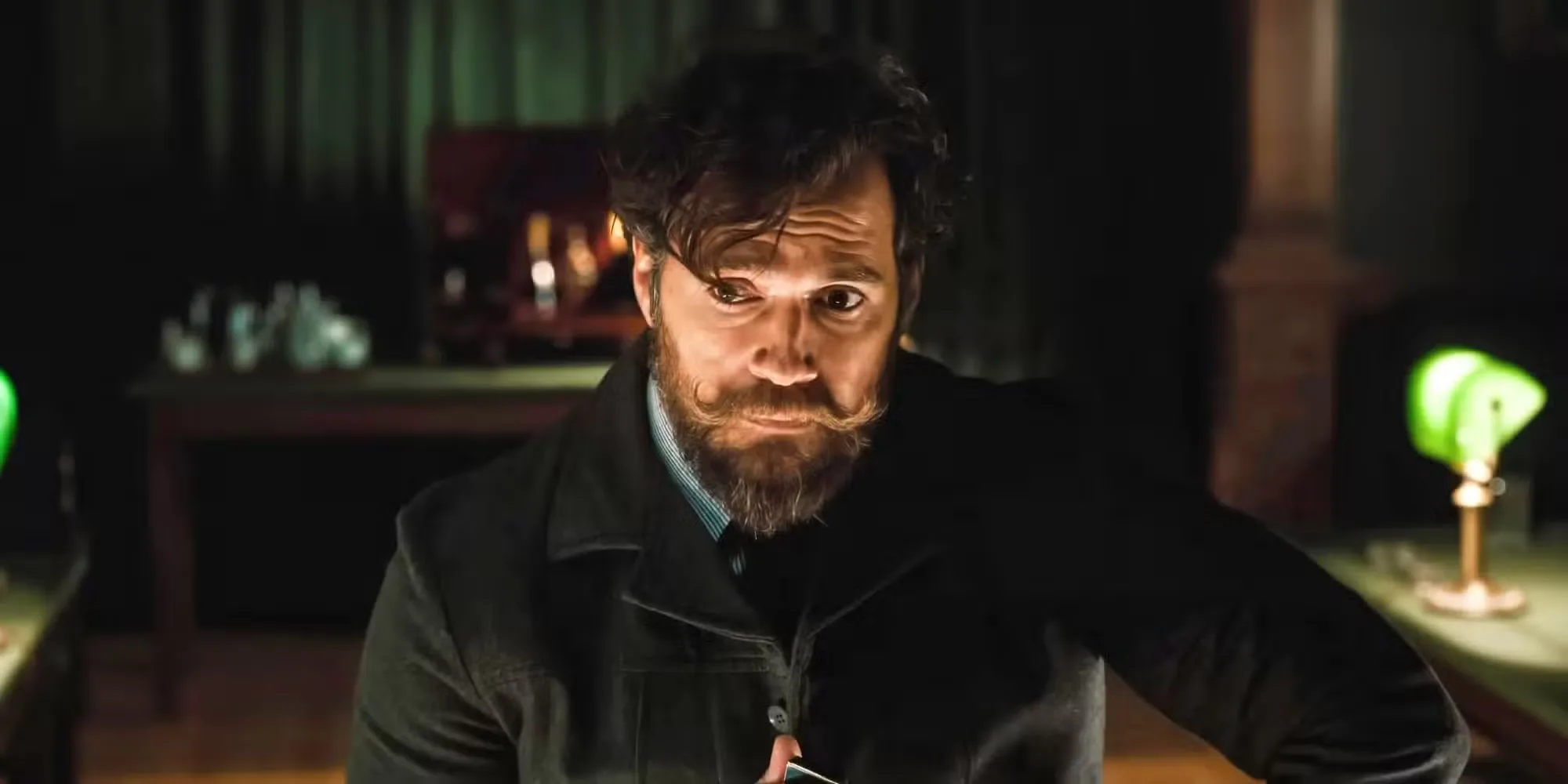 Henry Cavill sits in a study with eyebrows raised in The Ministry of Ungentlemanly Warfare