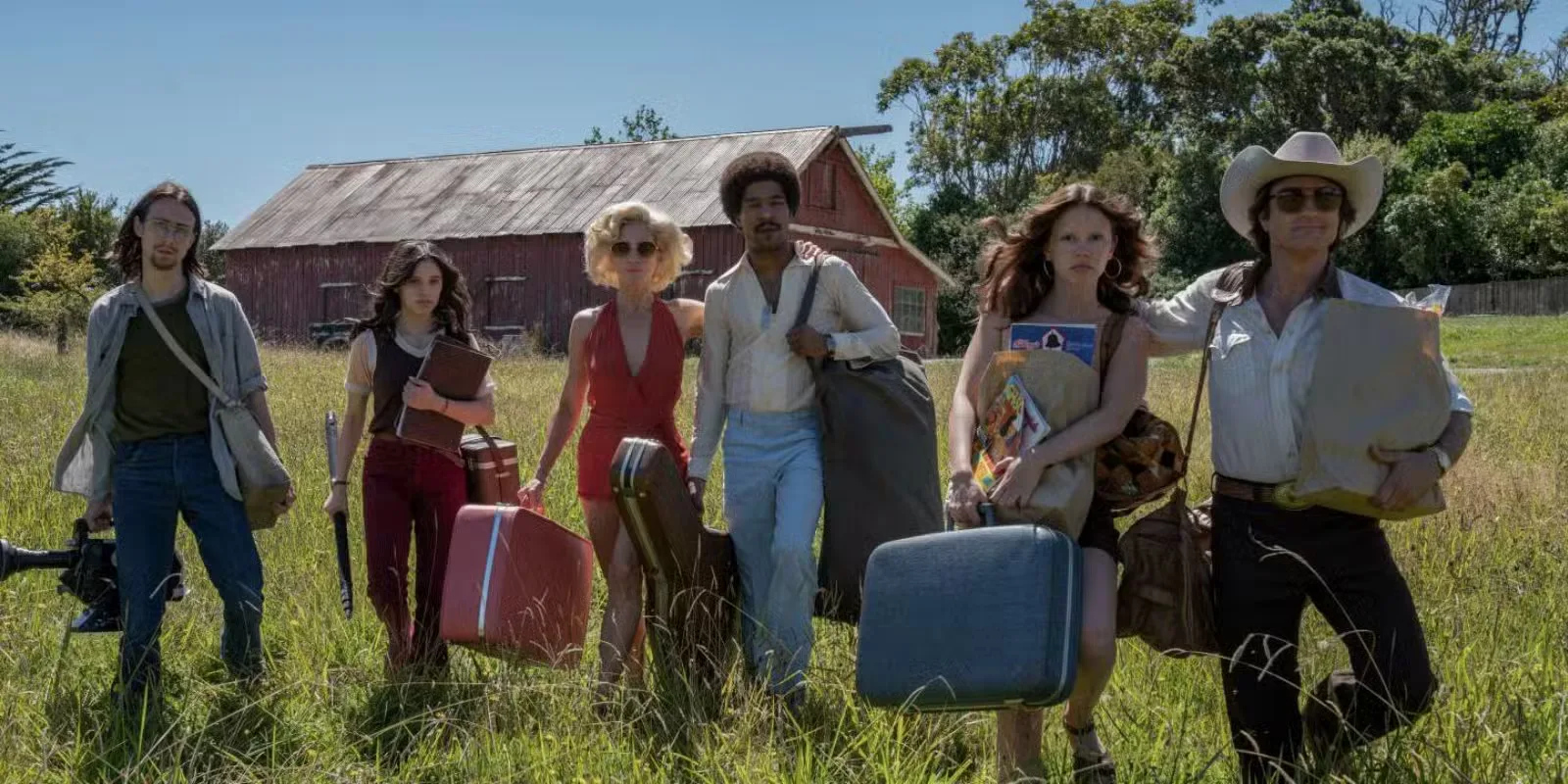 A group of filmmakers walking through a field with their equipment in Ti West's X