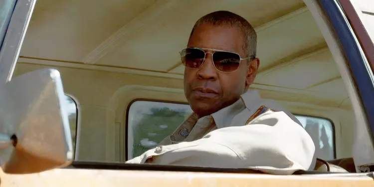 Denzel Washington as Joe Deacon in the drivers seat of a car looking in the mirror in The Little Things