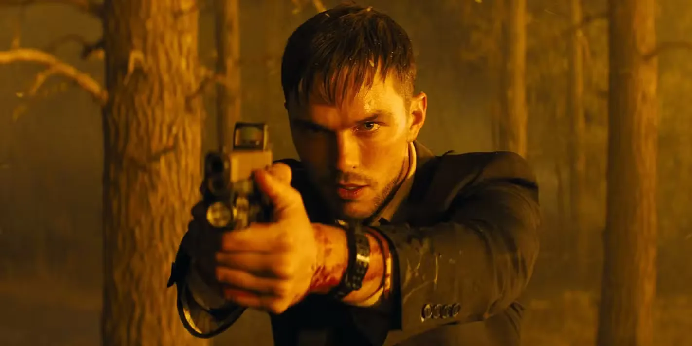 Nicholas Hoult aims a gun in a burning forest in Those Who Wish Me Dead