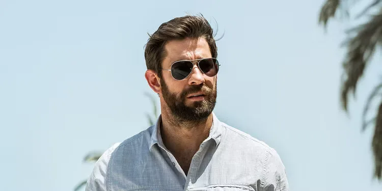 John Krasinski wearing sunglasses in a coastal town in 13 Hours: The Secret Soldiers of Benghazi