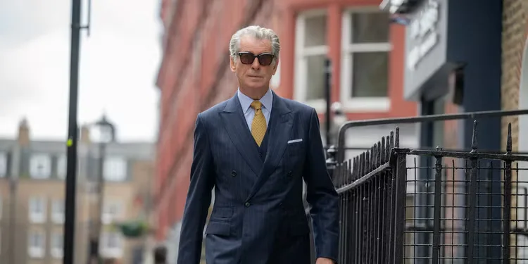 Pierce Brosnan walking down a street in a suit in Black Bag.