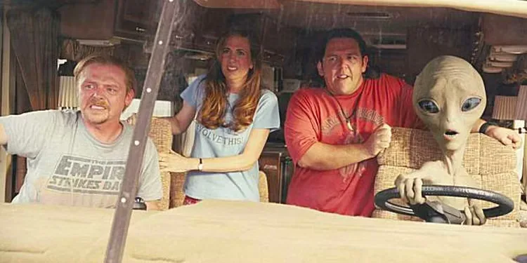 An alien drives an RV as the passengers watch on with concern.