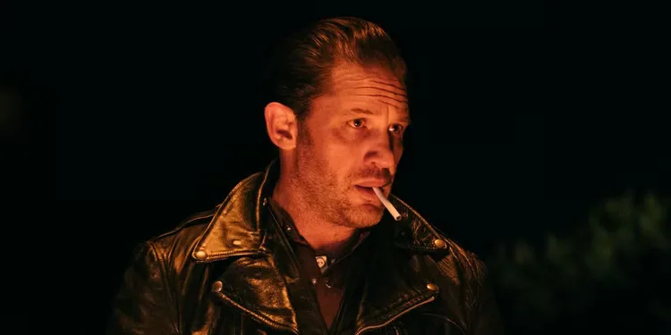 Tom Hardy with a cigarette in his mouth as Johnny in The Bikeriders.