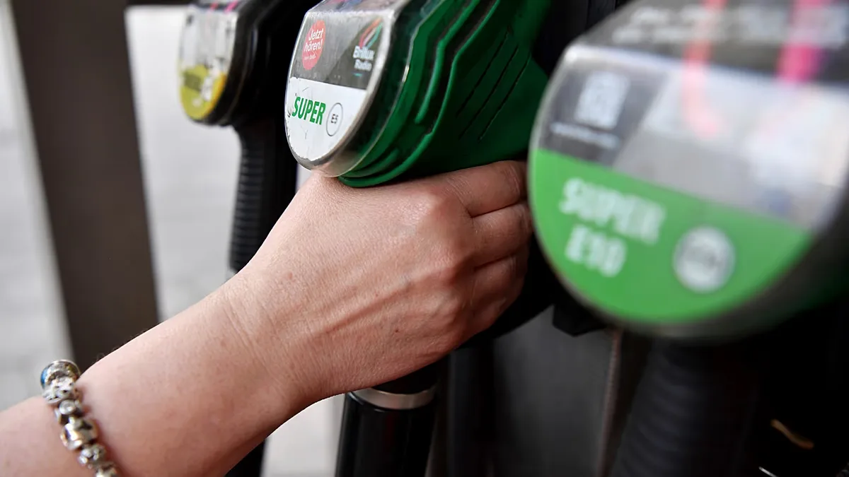 A customer reaches for a pump at a gas station in Berlin on Friday, June 13, 2025.