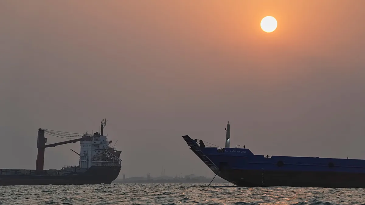 FILE. The sun sets over commercial vessels anchored in the Strait of Hormuz off Bandar Abbas, Iran, 6 Sept. 2026
