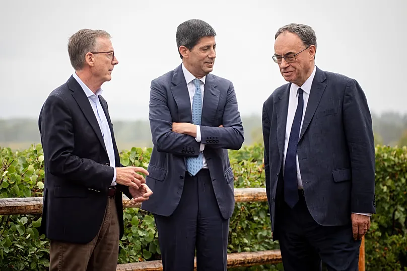 FILE. Fed Chair Kevin Warsh talks to Bank of England Governor Andrew Bailey and Bank of Canada Governor Tiff Macklem at the Jackson Hole Symposium, 28 Aug. 2026