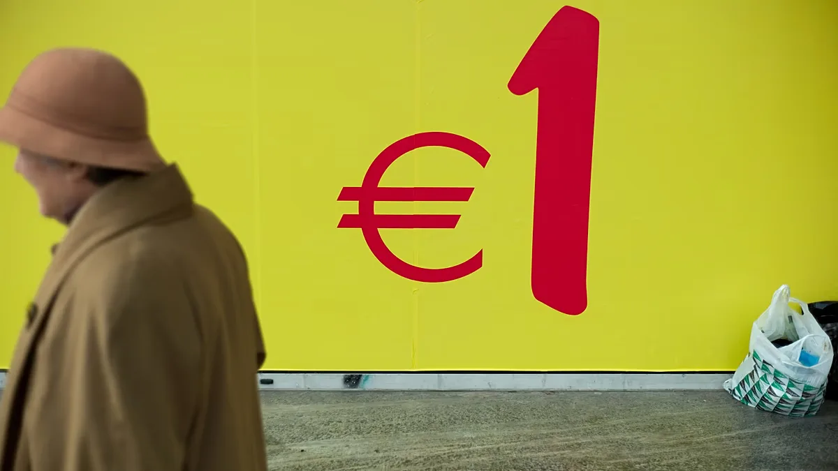 A woman walks past a supermarket in Lisbon, Portugal.