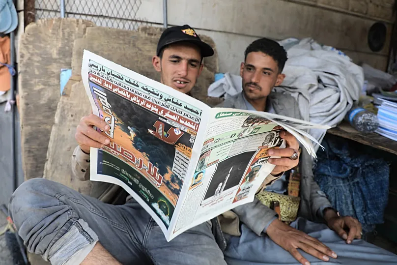 FILE: People read a newspaper to follow the war news at a shop in Sana'a, 8 September 2026