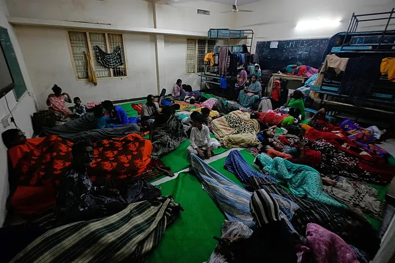 People gather at a temporary shelter set up inside a school as Cyclone Arnab approaches the Andhra Pradesh coast in Kakinada, India, late Tuesday, Oct. 27, 2026.