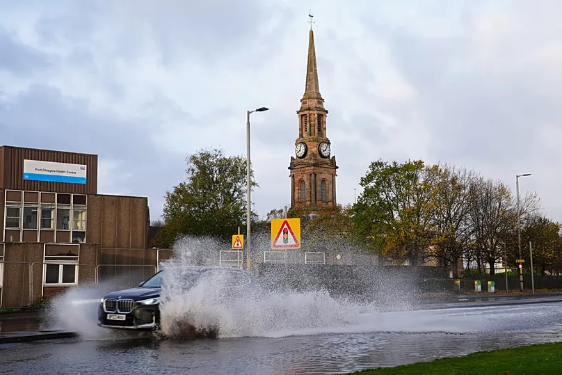 A car drives on the flooded A8 in Port Glasgow, Scotland, Sunday, Oct. 25, 2026, after Storm Boelo passed through the area. (Jane Barlow/PA via AP)