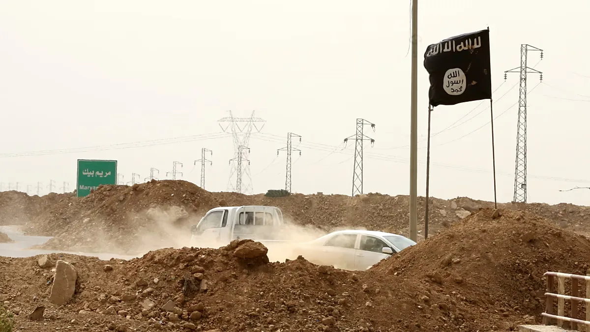 Islamic State militants walk past a checkpoint in the village of Maryam Begg, north of Baghdad in Iraq, on 29 September 2014.