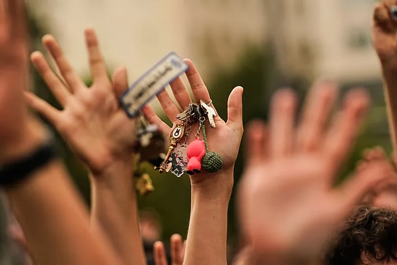 A woman, holding a set of keys in her hand, protests during a housing demonstration.