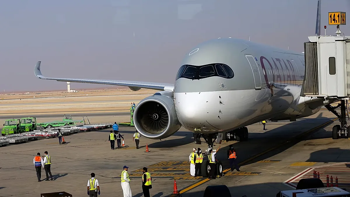 Saudi airport officials surround a Qatar Airways plane at King Khalid Airport in Riyadh, Saudi Arabia, Monday, Jan. 11, 2021.
