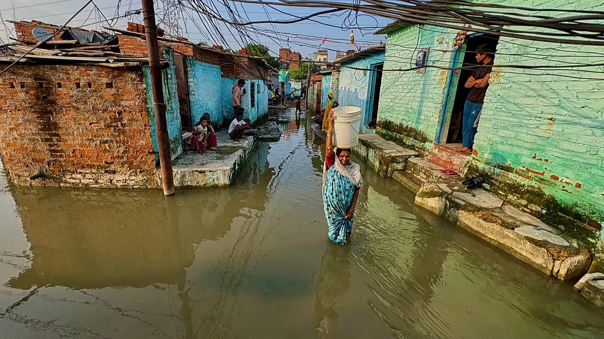 A woman wades through floodwaters in her neighbourhood following heavy rains in Kanpur, 22 September, 2026